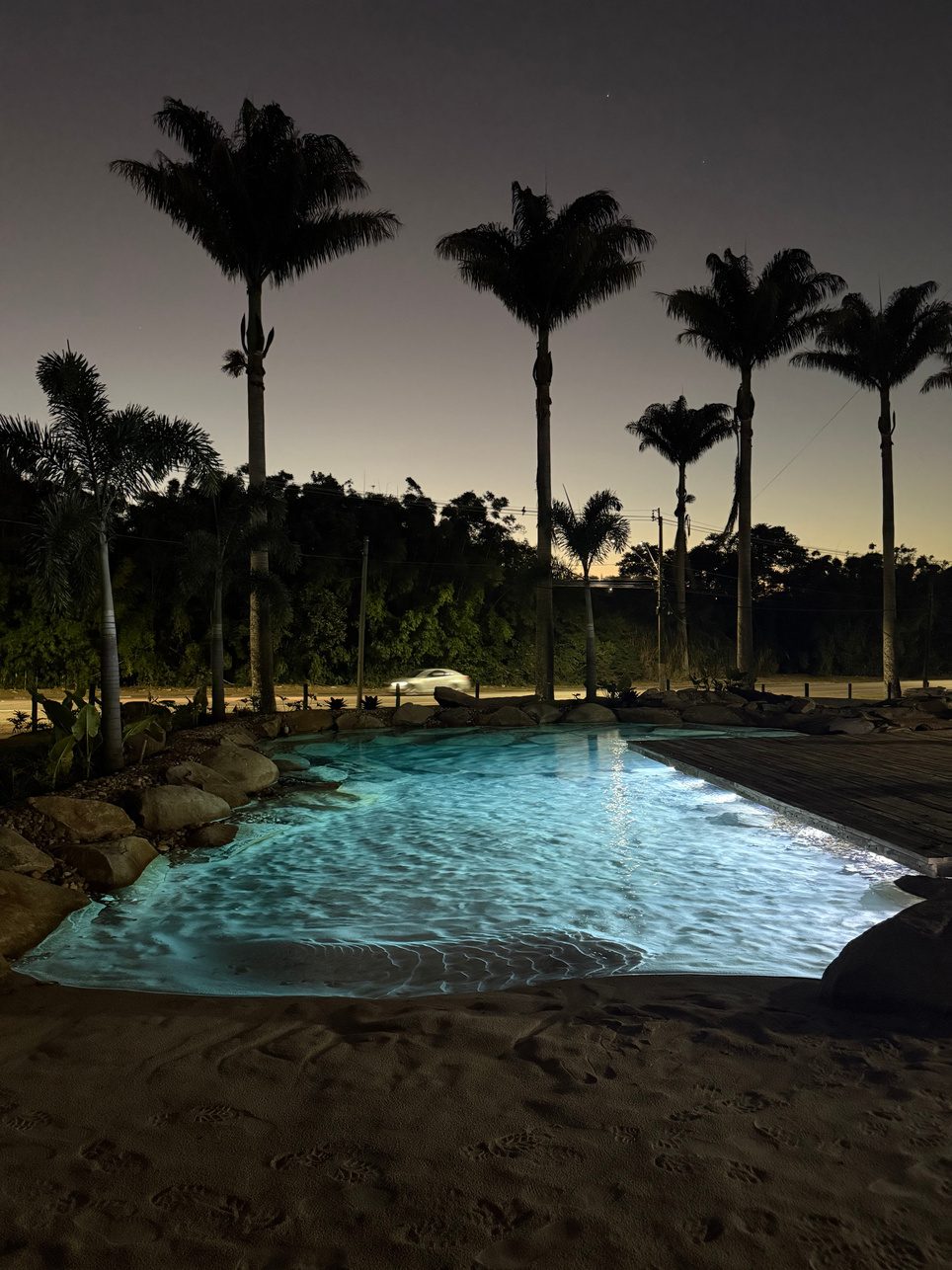 Natural lagoon at dusk framed by tall palms